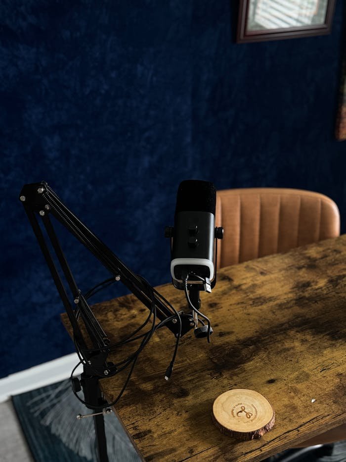 A dynamic microphone setup for podcasting on a rustic wooden table in a recording studio.